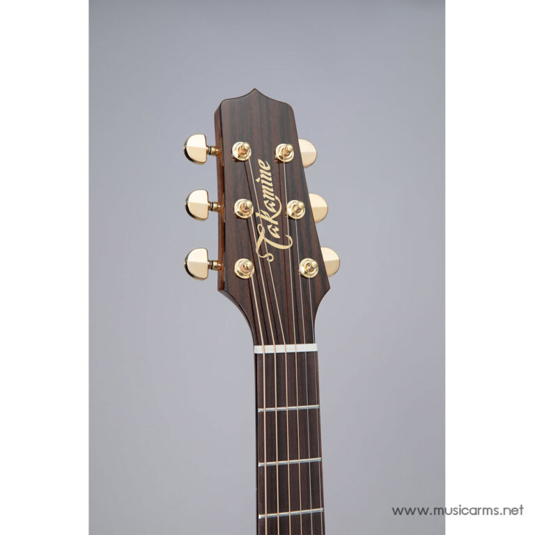 Close-up of a Takamine acoustic guitar headstock with gold tuning pegs, logo, and strings against a neutral gray background ขายราคาพิเศษ