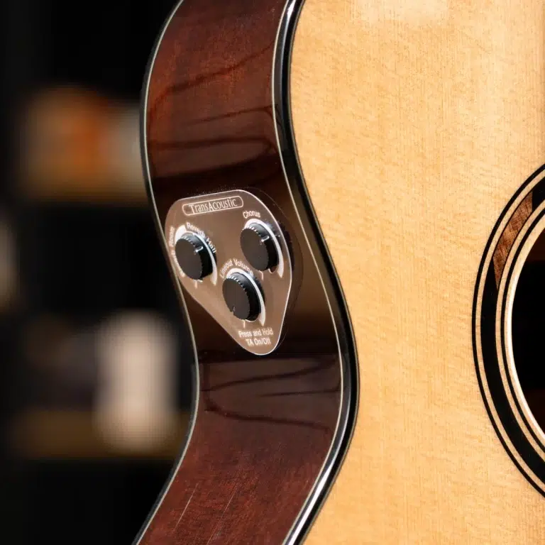 Close-up of an acoustic guitar body showing a built-in control panel with three knobs (Volume, Reverb/Chorus) on the dark side of the guitar. ขายราคาพิเศษ