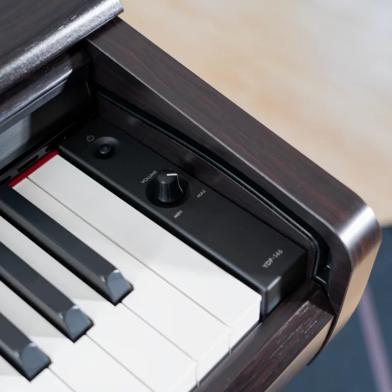 Close-up of a piano/keyboard with a black volume knob on a dark control panel above the white and black keys. ขายราคาพิเศษ
