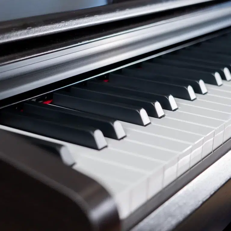 Close-up of a piano keyboard viewed from an angled perspective, showing black and white keys. ขายราคาพิเศษ