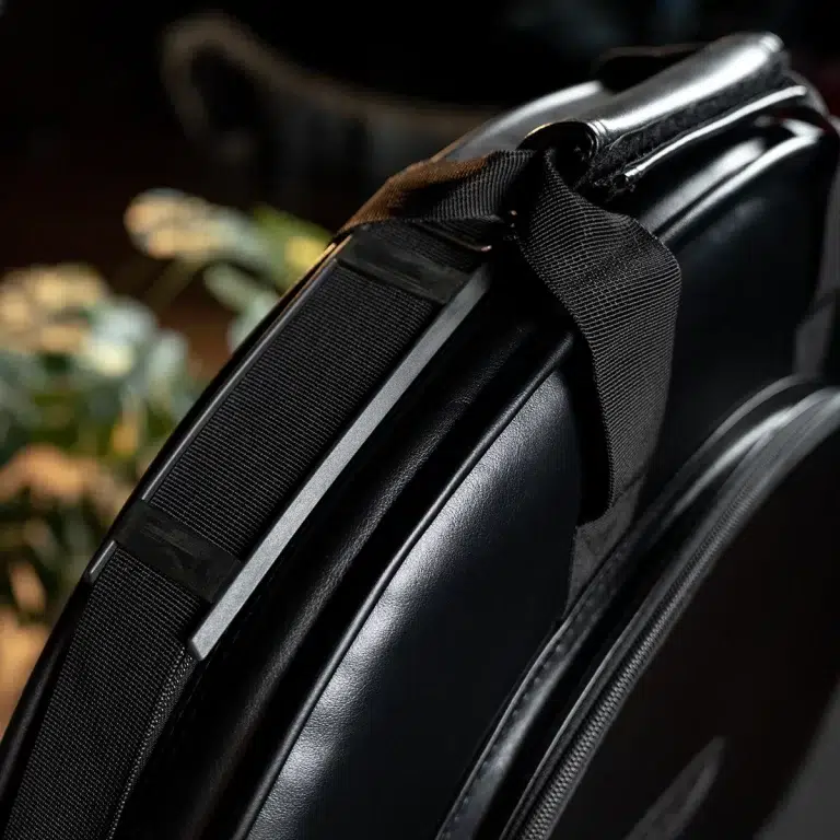 Close-up of a black backpack strap attached to a sleek black laptop bag, showing the padded edge and hardware. ขายราคาพิเศษ