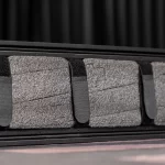 Close-up of dark gray bus/theater seat cushions with black fabric straps across them ขายราคาพิเศษ