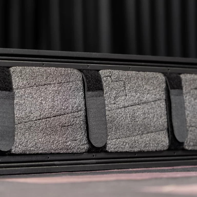 Close-up of dark gray bus/theater seat cushions with black fabric straps across them ขายราคาพิเศษ