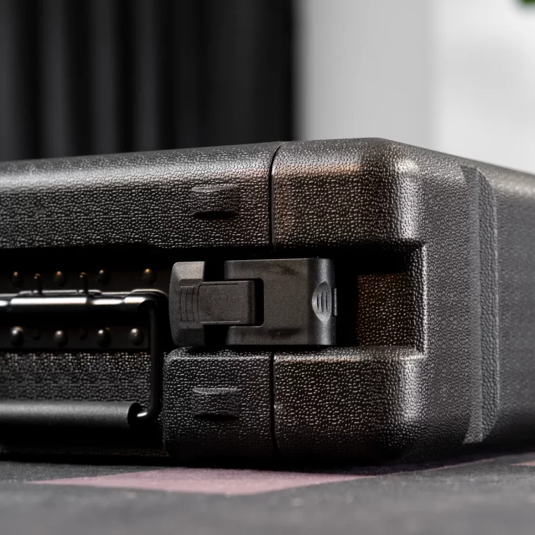 Close-up of a black textured hard case with a partially open latch and hinge details. ขายราคาพิเศษ
