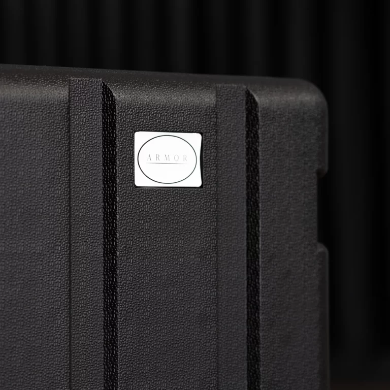 Close-up of a black textured hard case with a white badge reading ARMOR inside a circle. ขายราคาพิเศษ