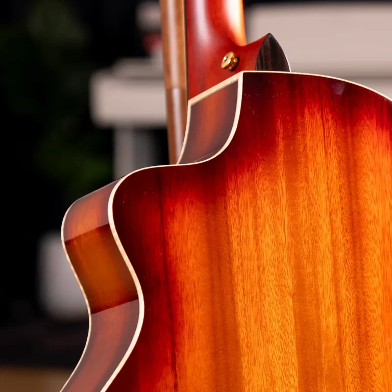 Close-up of a glossy sunburst acoustic guitar back and side, highlighting curved binding and warm wood grain. ขายราคาพิเศษ
