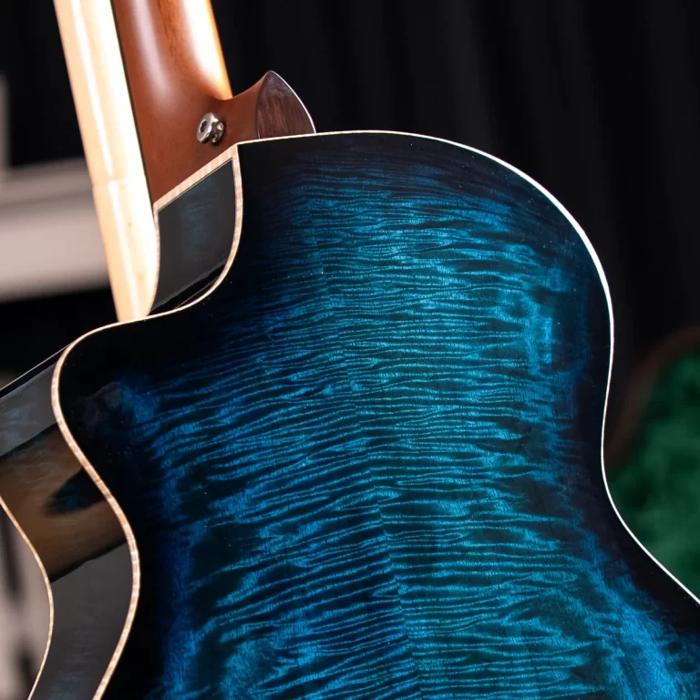 Close-up of a blue quilted‑maple guitar body with a natural neck and white edge binding. ขายราคาพิเศษ