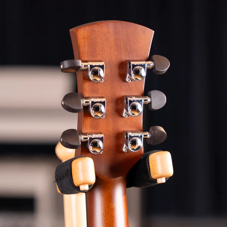 Close-up of a brown wooden guitar headstock with six chrome tuning pegs ขายราคาพิเศษ