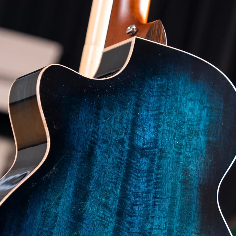 Close-up of a blue-green glossy guitar body with a cutaway and natural neck. ขายราคาพิเศษ