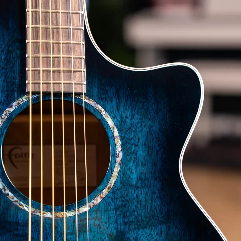Close-up of a blue acoustic guitar showing strings across the sound hole and glossy finish. ขายราคาพิเศษ