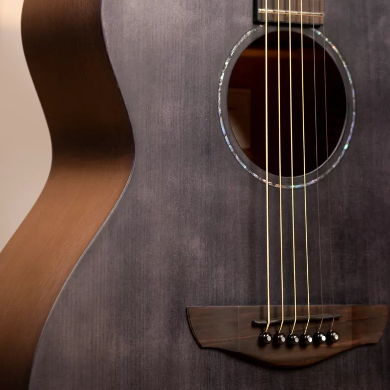 Close-up of a dark wooden acoustic guitar showing the soundhole, strings, and bridge. ขายราคาพิเศษ