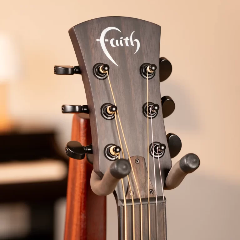 Close-up of a dark wood guitar headstock with six tuning pegs and strings; the Faith logo is visible on the headstock. ขายราคาพิเศษ