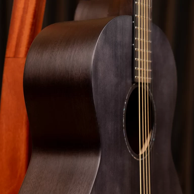 Close-up of a dark wooden acoustic guitar, showing the curved body, soundhole, and six strings. ขายราคาพิเศษ