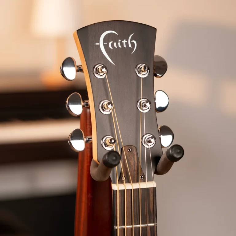 Headstock of an acoustic guitar with the Faith logo, six tuning pegs, and strings visible near the nut ขายราคาพิเศษ