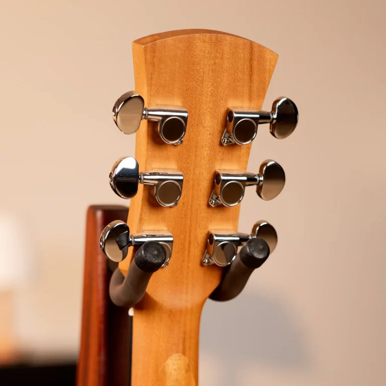 Close-up of a wooden guitar headstock with six chrome tuning pegs showing on the neck's side. ขายราคาพิเศษ