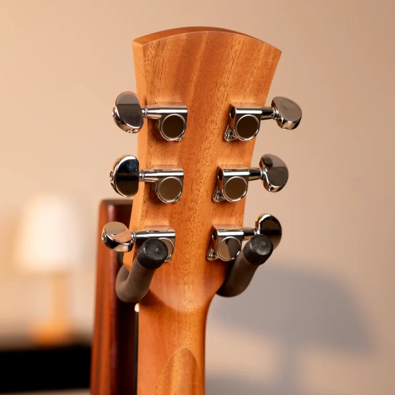 Close-up of a natural wood guitar headstock with six chrome tuning pegs on the back side. ขายราคาพิเศษ