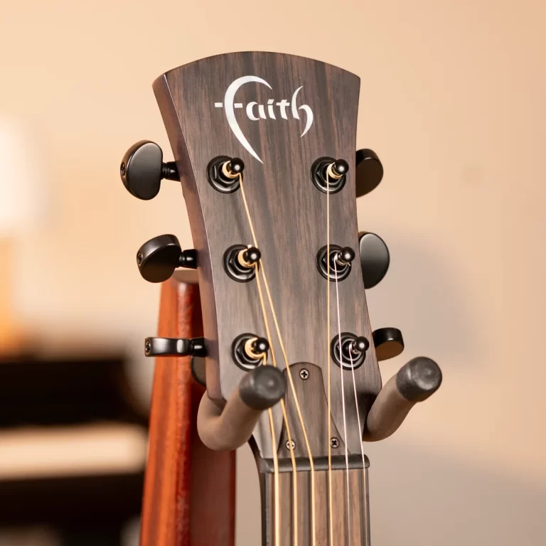 Close-up of a dark wood guitar headstock with six tuning pegs and light strings, showing the Faith logo. ขายราคาพิเศษ