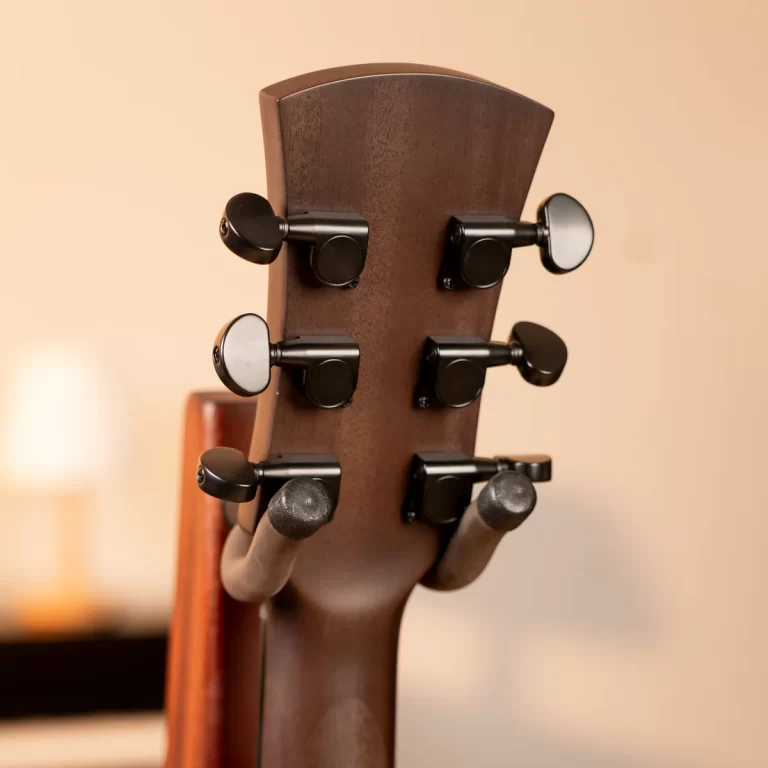 Close-up of a guitar headstock with black tuning pegs on a brown neck ขายราคาพิเศษ