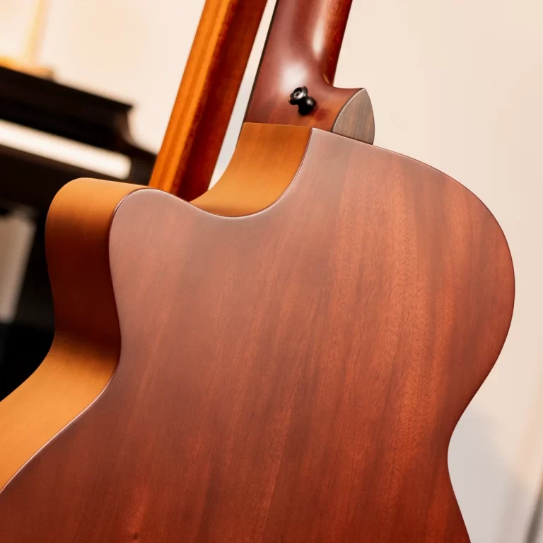 Close-up of the back of a wooden acoustic guitar, highlighting smooth grain and the neck joint at the top. ขายราคาพิเศษ