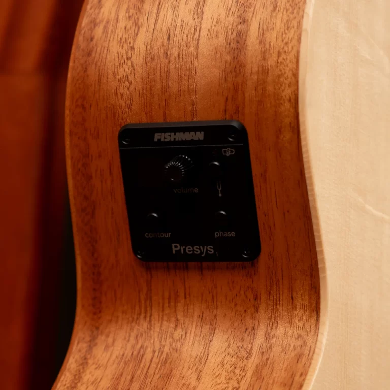 Close-up of a black Fishman Presys preamp panel on a wooden guitar body, showing volume knob and contour/phase controls ขายราคาพิเศษ