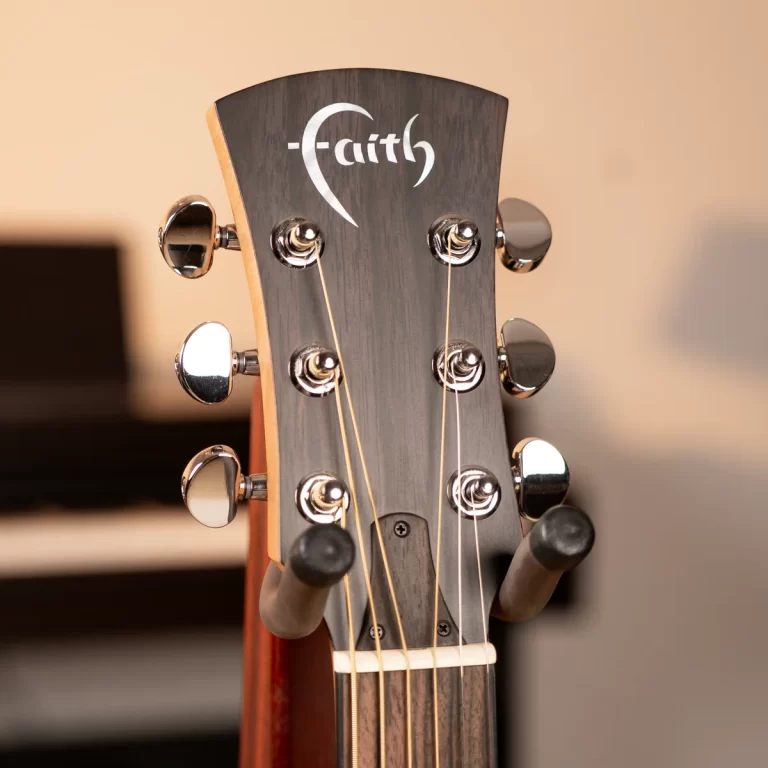 Guitar headstock with metal tuning pegs and a Faith logo etched on the wooden headstock. ขายราคาพิเศษ