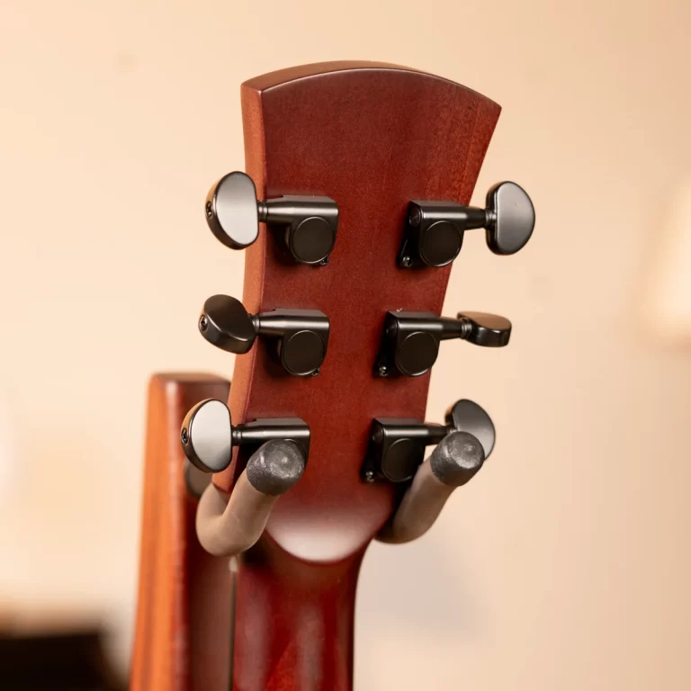 Back of a wooden guitar headstock with six black tuning pegs visible on both sides of the neck. ขายราคาพิเศษ