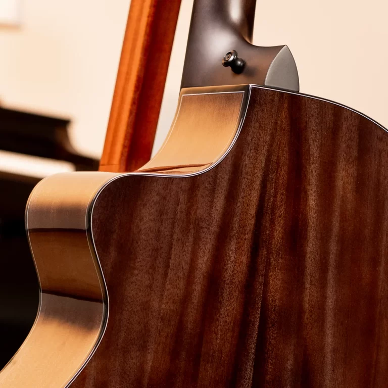 Close-up of the polished brown back and waist of an acoustic guitar, highlighting the wood grain and binding. ขายราคาพิเศษ