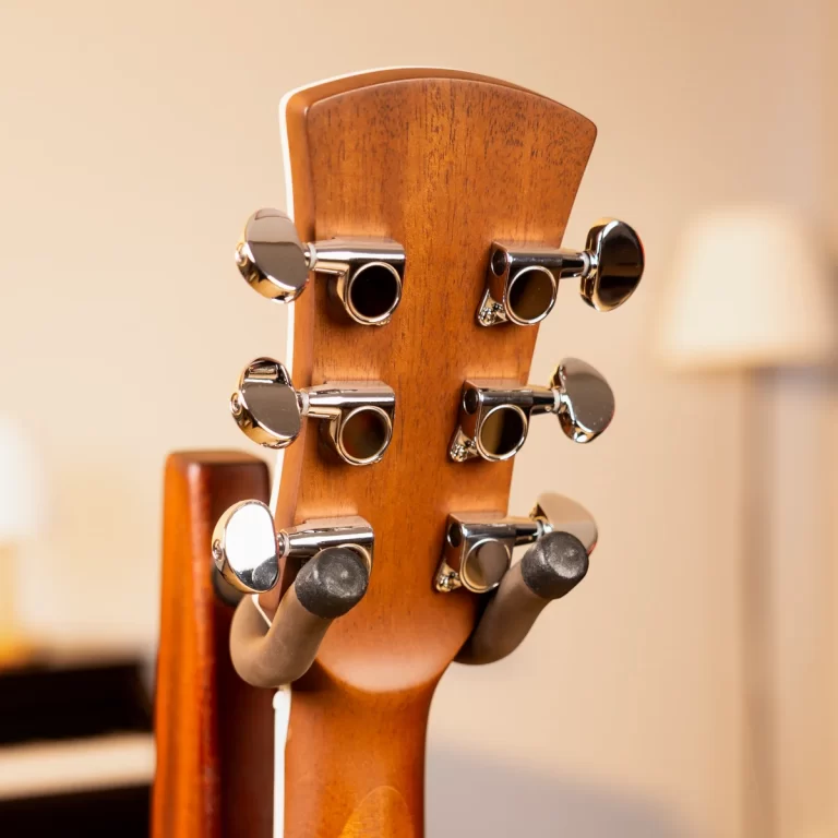 Back of a wooden guitar headstock with six chrome tuning pegs (strings not visible) insightfully showing the machine heads experience for tuning the strings ขายราคาพิเศษ