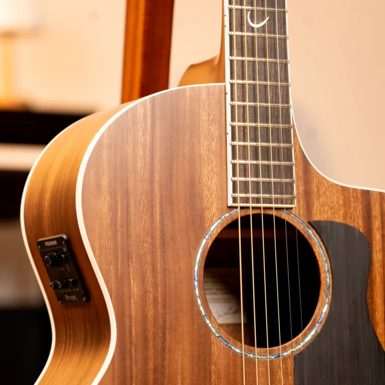 Close-up of a wooden acoustic guitar showing soundhole, strings, and fretboard. ขายราคาพิเศษ