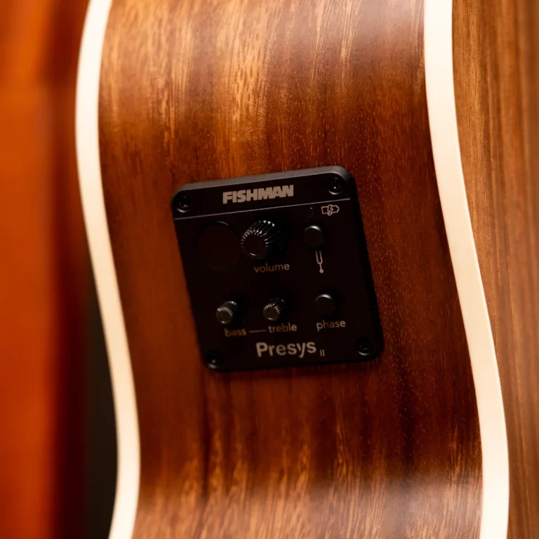 Close-up of a wood-bodied acoustic guitar showing the black Fishman Presys II preamp panel with volume, bass, treble, and phase controls on the back/sides. ขายราคาพิเศษ