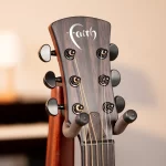 Close-up of a wooden guitar headstock with six tuning pegs and strings, featuring a stylized 'Earth' logo on the headstock. ขายราคาพิเศษ