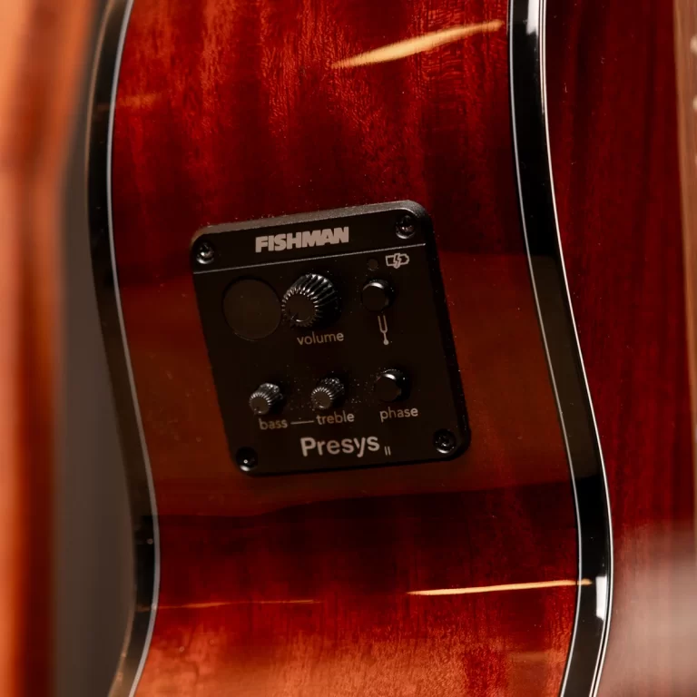Close-up of a Fishman Presys II preamp mounted on a glossy red acoustic guitar body, showing volume, bass/treble, and phase controls. ขายราคาพิเศษ
