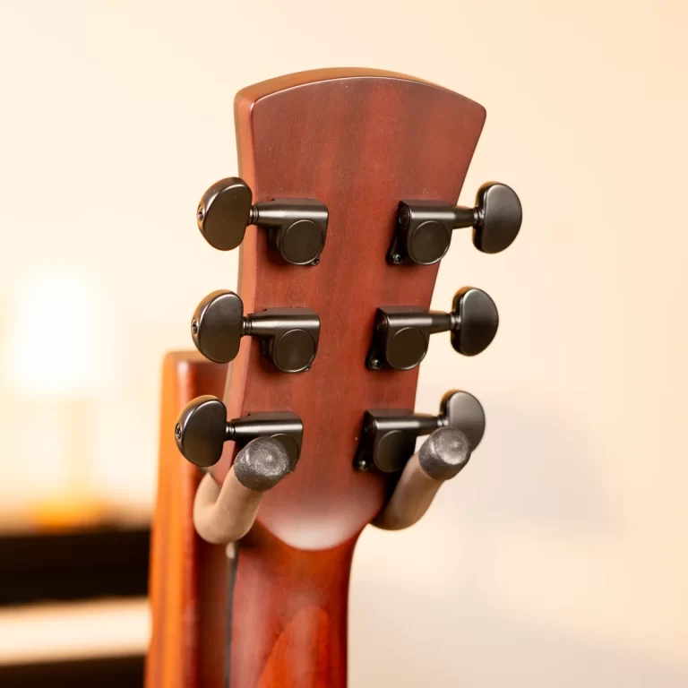 Close-up of a wooden guitar headstock with six black tuning pegs visible on one side ขายราคาพิเศษ