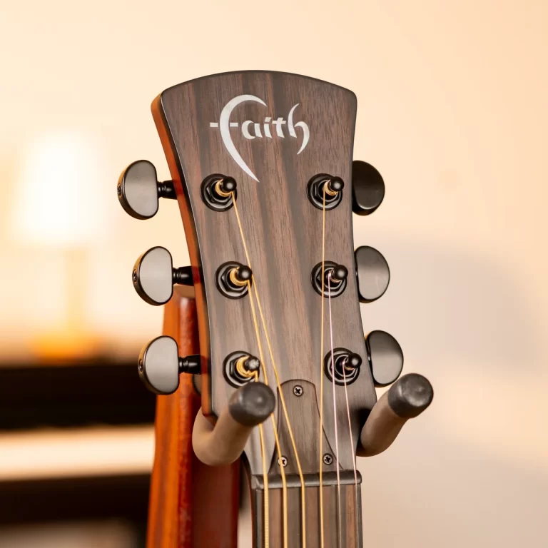 Close-up of a wooden guitar headstock with six tuning pegs and strings, Faith logo visible on the headstock ขายราคาพิเศษ