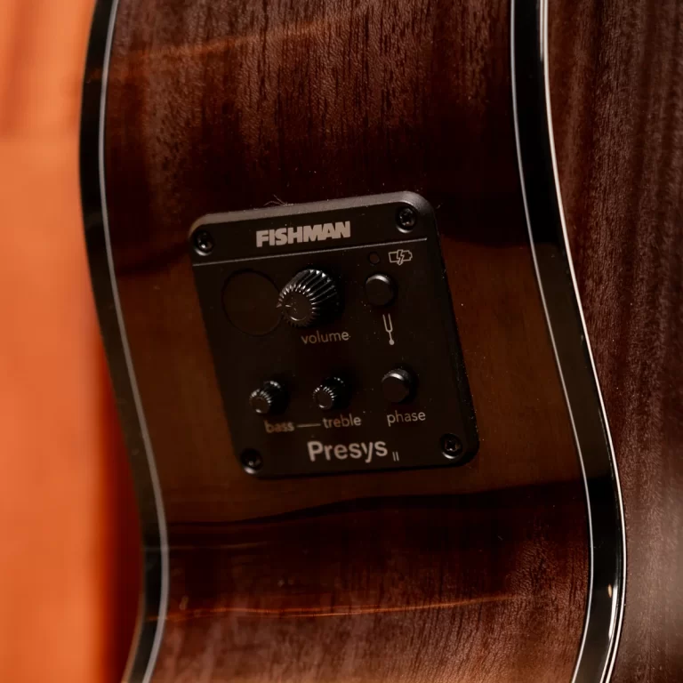 Close-up of a Fishman Presys II preamp panel mounted inside an acoustic guitar, showing volume, bass, treble, and phase controls on a wood body ขายราคาพิเศษ
