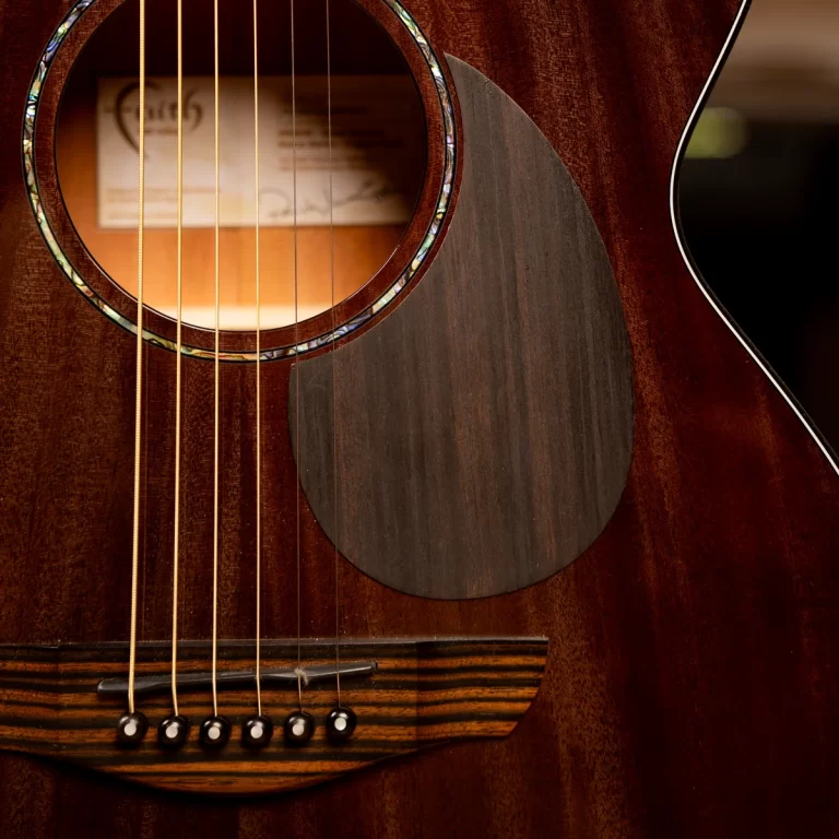 Close-up of an acoustic guitar showing the soundhole, six strings, and wooden bridge. ขายราคาพิเศษ