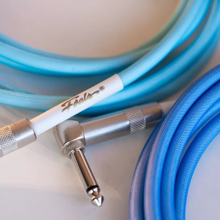 Blue audio cables with a metallic 1/4-inch plug, coiled on a light surface ขายราคาพิเศษ