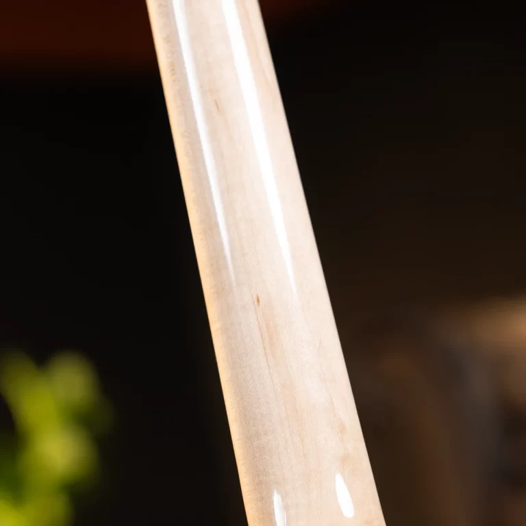 Close-up of a light, polished wooden dowel or rod against a dark background. ขายราคาพิเศษ
