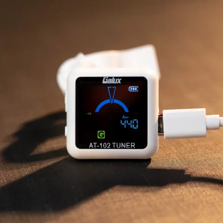 White Galux AT-102 tuner device with a connected cable, front display showing a blue tuning arc and 'AT-102 TUNER' label ขายราคาพิเศษ