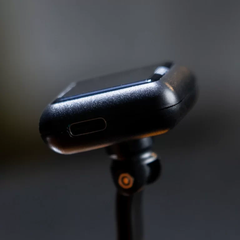 Close-up of a small black camera or action cam mounted on a tripod with a visible USB-C port on the side. ขายราคาพิเศษ