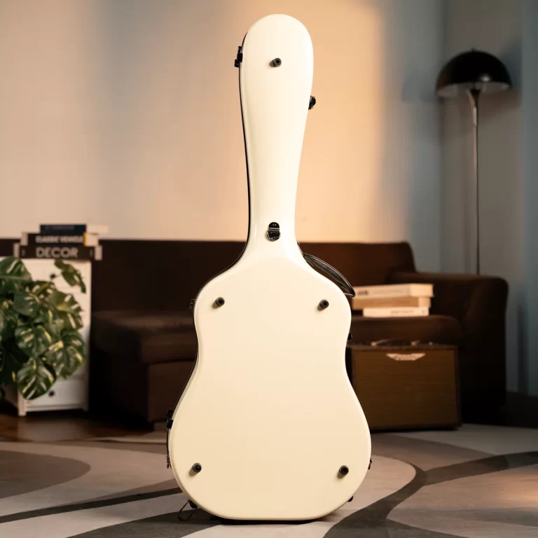 White guitar case standing upright in a living room, with a sofa, plant, and floor lamp in the background. ขายราคาพิเศษ