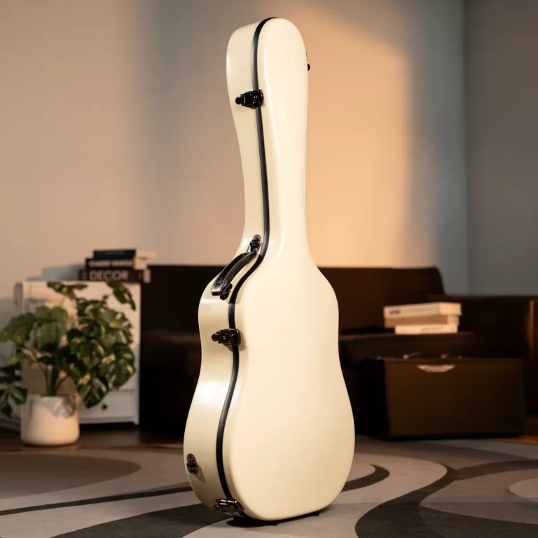 Cream-colored guitar case standing upright in a living room, with a plant, sofa, and books in the background. ขายราคาพิเศษ
