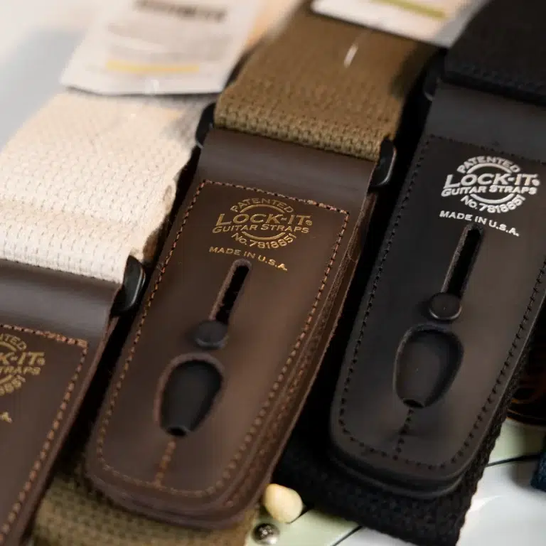Close-up of brown leather guitar strap ends stamped 'Lock-It Guitar Straps' with 'Made in U.S.A.' text. ขายราคาพิเศษ