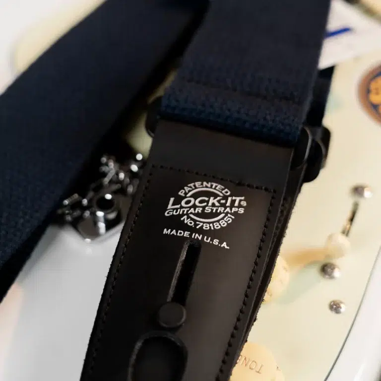 Close-up of a black leather guitar strap with the 'Lock-It Guitar Straps' logo and 'Made in U.S.A.' text visible. ขายราคาพิเศษ
