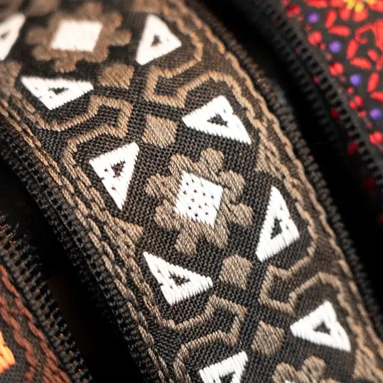 Close-up of a patterned fabric with interlocking geometric shapes in black, brown, and white. ขายราคาพิเศษ