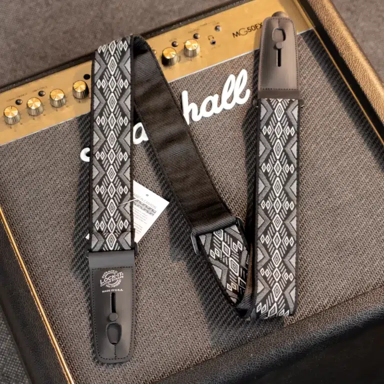 Geometric gray guitar strap with leather ends resting on a Marshall MG50FX amplifier. ขายราคาพิเศษ