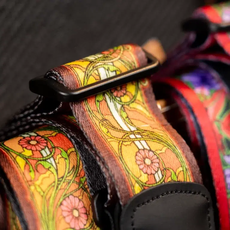 Close-up of a vibrant floral-patterned leather strap with a black buckle, part of a bag or harness. ขายราคาพิเศษ
