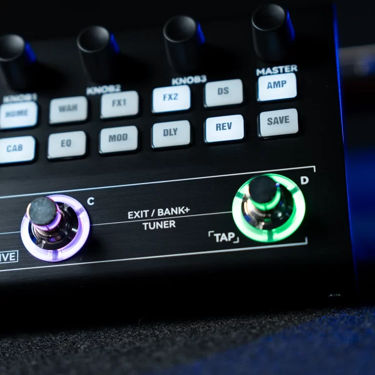 Close-up of a guitar effects unit with labeled function buttons (FX, REV, SAVE) and two illuminated knobs (purple left, green right). ขายราคาพิเศษ