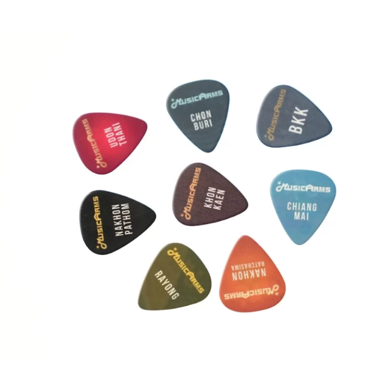A circle of nine colorful guitar picks laid out on a white background, each with printed text or logos. ขายราคาพิเศษ