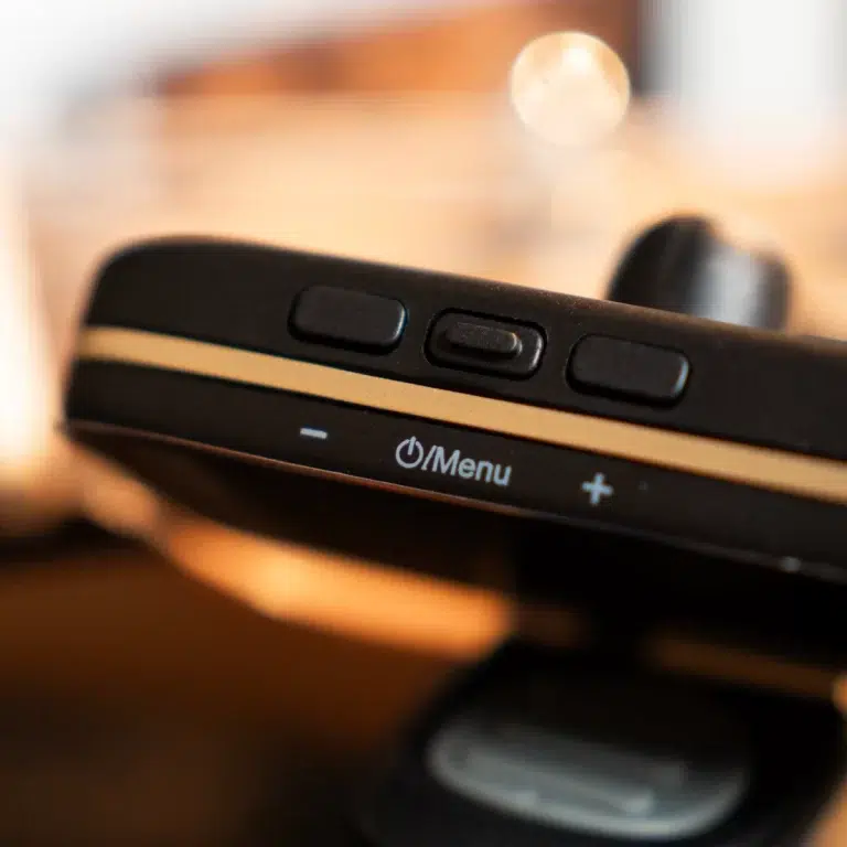 Close-up of a device's control panel with three side buttons and a Menu label on a black surface with a gold trim. ขายราคาพิเศษ